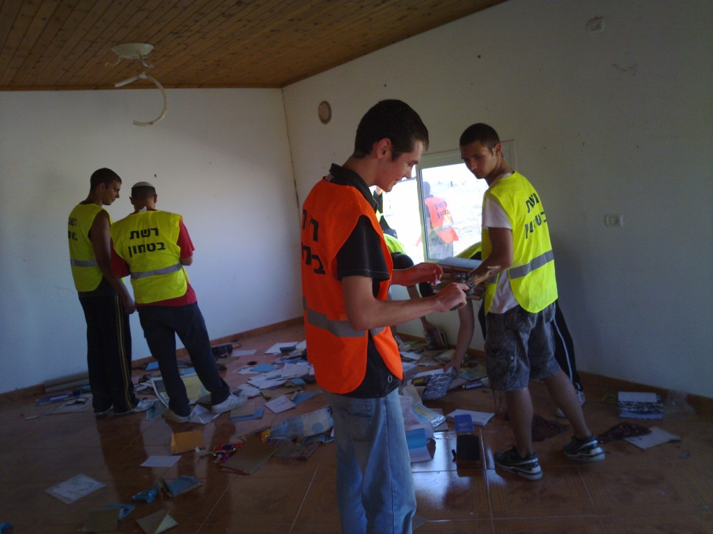 Israeli police volunteers go through the belongings an al-Arakib family